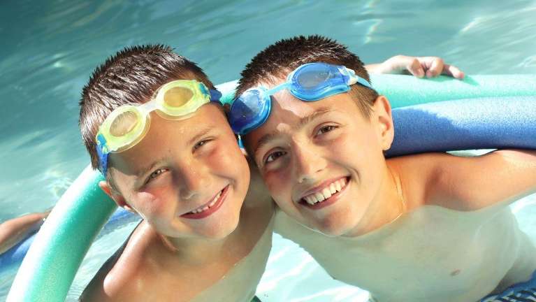 Kids in a St. Cloud pool smiling with their good teeth